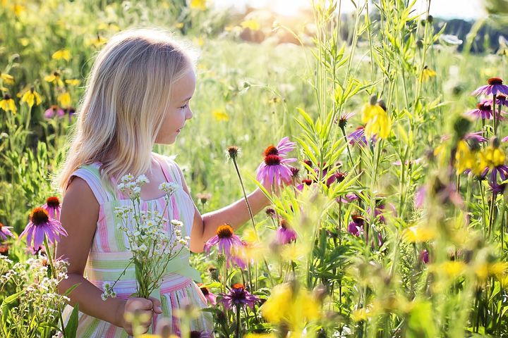 A kid picking a flower and feeling happy