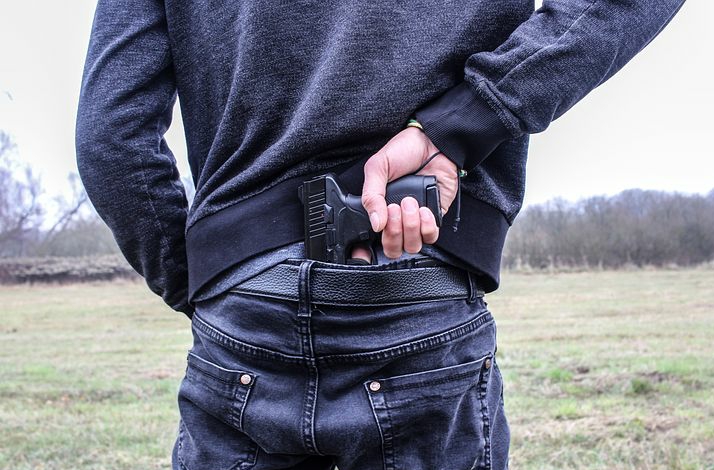 A man hiding a gun behind his back