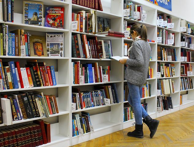 A Girl with a book in a library 