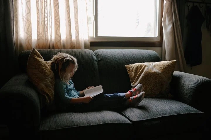 A kid spending time with God reading the Bible 